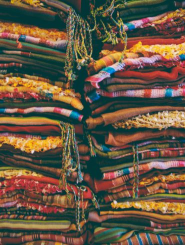 stacks of brightly colored fabric stacked high